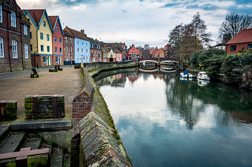 Building and bridge alongside riverside walk on the river Wensum in central Norwich