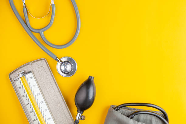 stethoscope and blood pressure stethoscope and blood pressure on yellow background with copy space, health care and medical concept blood pressure medication stock pictures, royalty-free photos & images