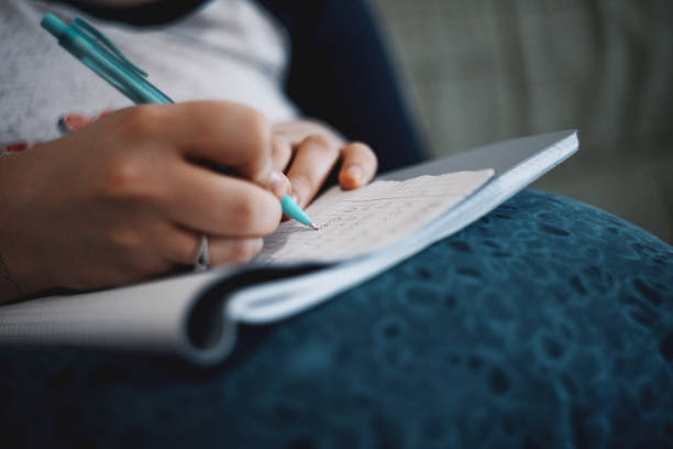Close-Up Of Woman Hand Writing In Notebook stock photo