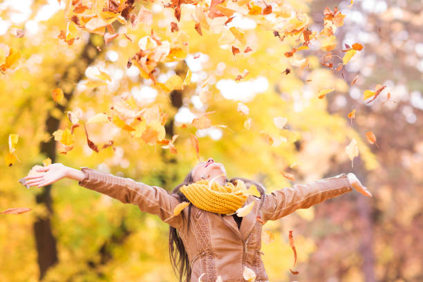 istock Playful woman throwing autumn leaves. 1009990906