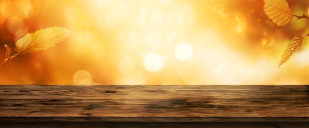 istock Golden autumn background and wooden table 1009999194