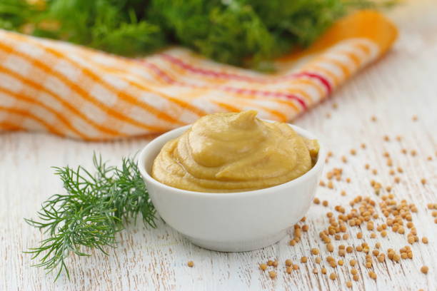 Mustard in bowl Mustard sauce in white bowl. Stock photo dijon stock pictures, royalty-free photos & images