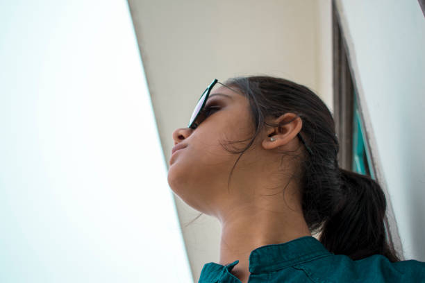 istock confident Indian girl looking up wearing sunglasses 1010001740