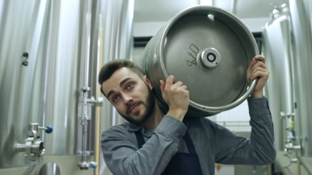 Young Brewery Worker Walking with Beer Keg