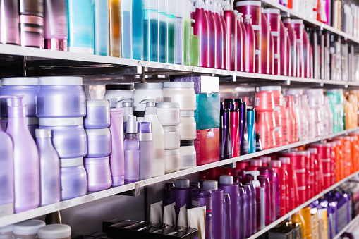 Image of shelves with fashionable modern beautiful stylish conditioners and mousses for hair in the store.