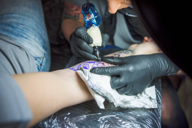 istock Young woman getting a tattoo done on her arm 1010014930
