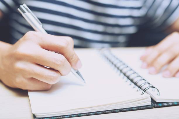 istock close up hand people are writing Record Lecture notepad into the book. 1010016252