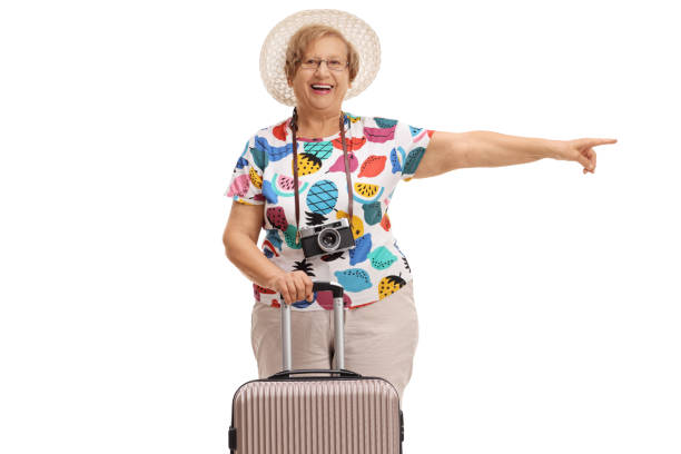 istock Elderly female tourist with a suitcase pointing 1010022876