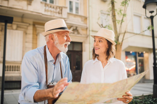 istock Older tourists holding a map and talking 1010023326