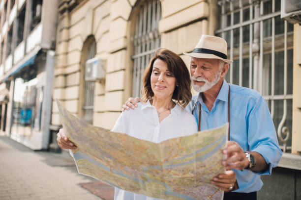 istock Married couple hugging and looking at touristic map together 1010023474
