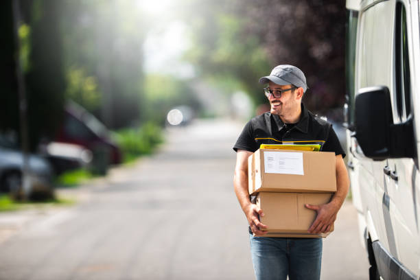 Package Delivery Postman delivery a package to a customer. delivery person stock pictures, royalty-free photos & images