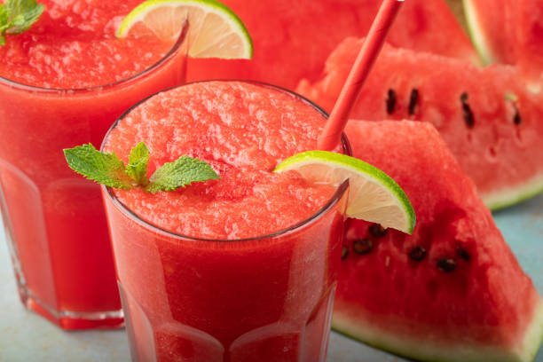 istock Watermelon slushie with lime, summer refreshing drink in tall glasses on a blue rusty background 1010028470