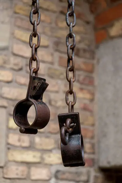 Old shackles against a brick wall