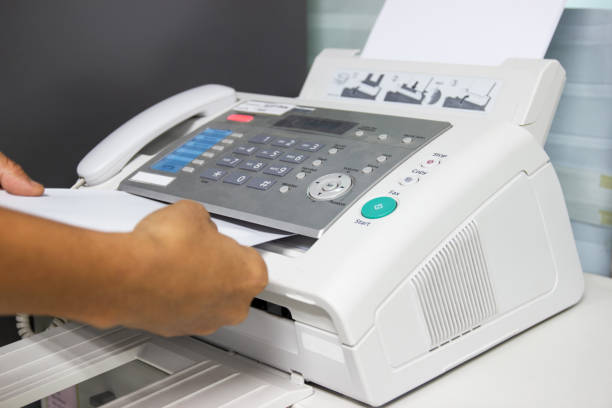 istock hand man are using a fax machine in the office. Business concept 1010031878