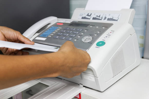istock hand man are using a fax machine in the office. Business concept 1010031988