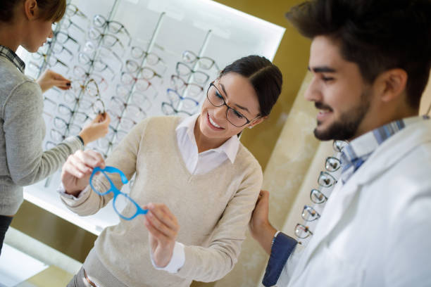 istock Selecting eyeglasses in optical store with assistance of optometrist 1010032944