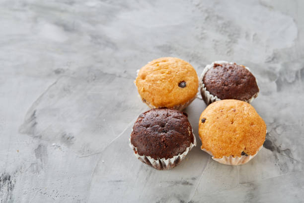 istock Tasty muffins arranged in pattern on light textured background, close-up, shallow depth of field, selective focus. 1010035542