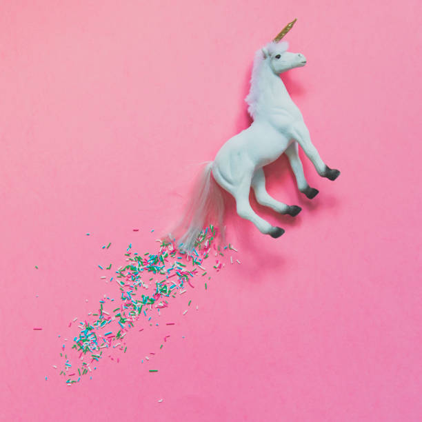istock White unicorn flying with a train of confetti. 1010035850