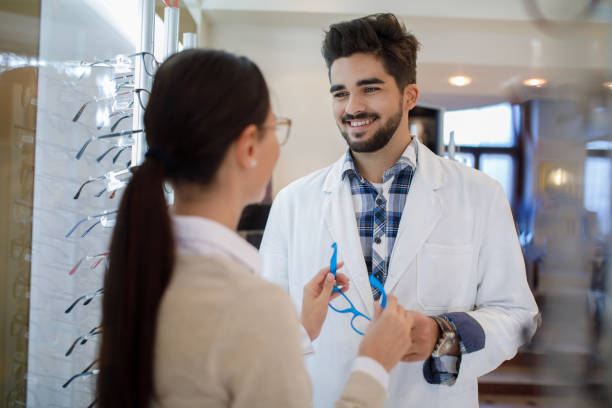 istock Selecting eyeglasses in optical store with assistance of optometrist 1010036954