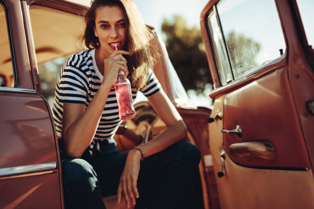 istock Beautiful woman drinking soft drinking in the car 1010039342