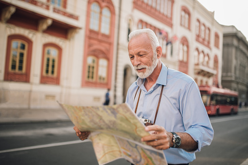 Senior man reading map on vacation