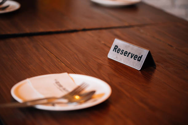 'Reserved' Sign on dining table in restaurant with spoon, fork and plate.