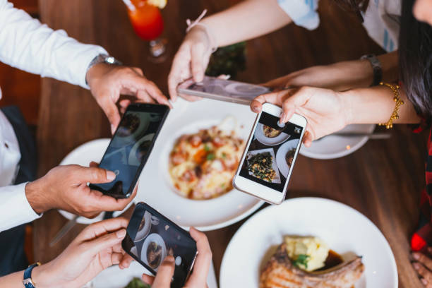 grupo de amigos, salir y tomar una foto de comida italiana junto con el teléfono móvil. - comer fotos fotografías e imágenes de stock