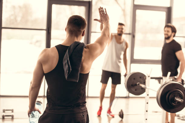 istock handsome sportsmen waving hands in gym 1010054772