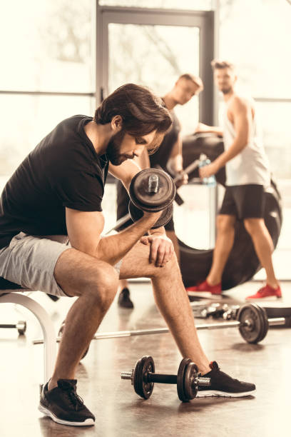 istock side view of handsome muscular man training with dumbbells in gym 1010055018