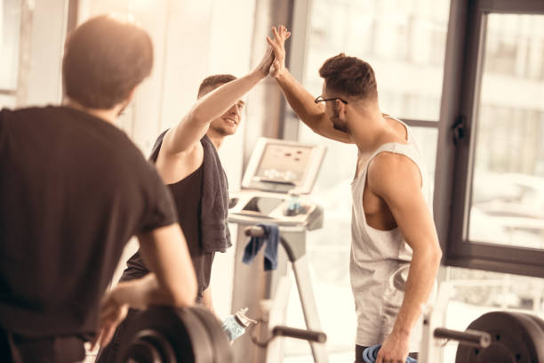istock handsome sportsmen giving high five in gym 1010058264