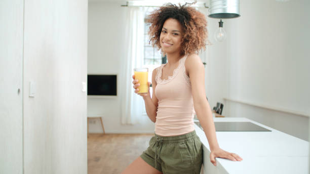istock Happy mixed race woman holding smoothie, looking to camera. 1010059234
