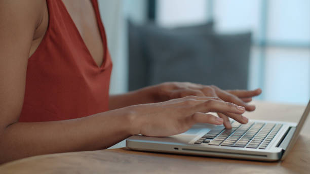 istock Close up of young Afro American female hands using laptop computer while sitting at table. 1010059526
