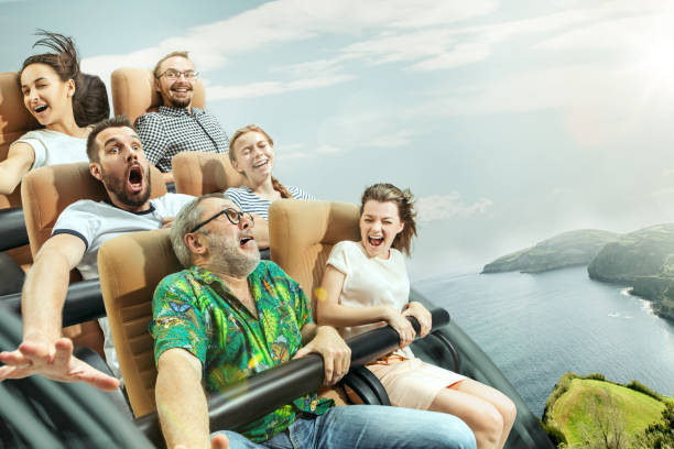 las emociones felices de los hombres y las mujeres que tienen buen tiempo en una montaña rusa en el parque - park and ride fotografías e imágenes de stock