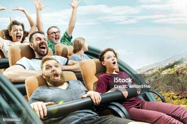 The Happy Emotions Of Men And Women Having Good Time On A Roller Coaster In The Park Stock Photo - Download Image Now