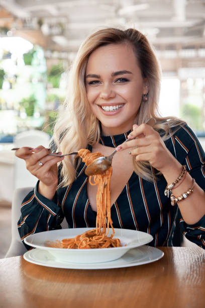 istock Sensual woman rolling spaghetti and keeping on a fork to eat 1010064810
