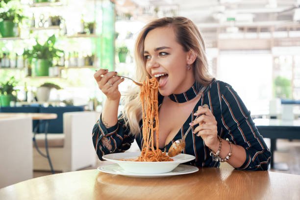 istock Beautiful woman rolling spaghetti and keeping on a fork to eat 1010064866