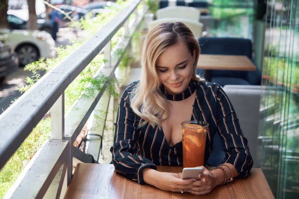istock Adorable blond woman using smartphone sitting on the terrace 1010064972