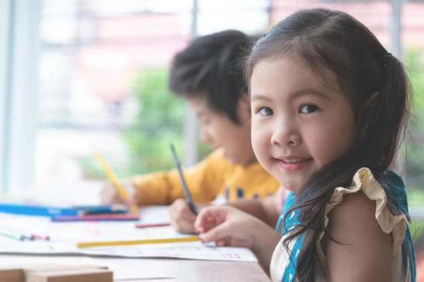 menina asiática é desenho na aula de arte do jardim de infância - preschooler child chinese ethnicity asian ethnicity - fotografias e filmes do acervo