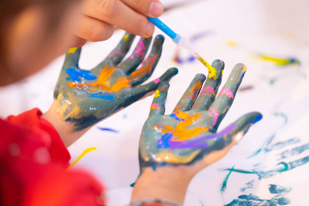istock kids with dirty painted hand in art classroom 1010065452