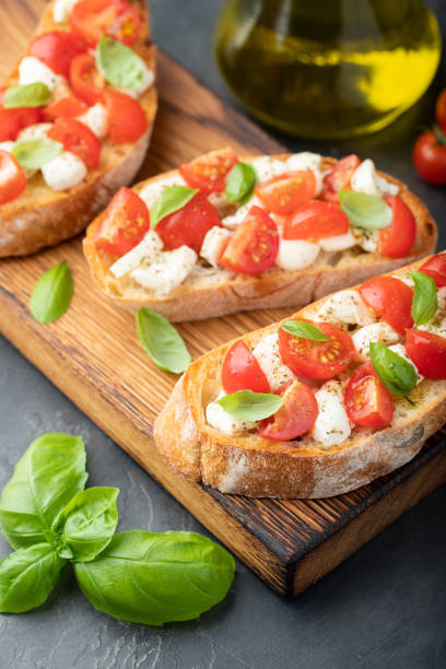 istock Bruschetta with tomatoes, mozzarella cheese and basil on a cutting board. Traditional italian appetizer or snack, antipasto 1010068872