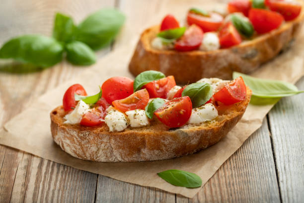 istock Bruschetta with tomatoes, mozzarella cheese and basil on a old rustic table. Traditional italian appetizer or snack, antipasto 1010068902
