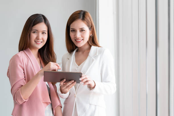 istock Two business woman is discussing on tablet looking at camera 1010069248