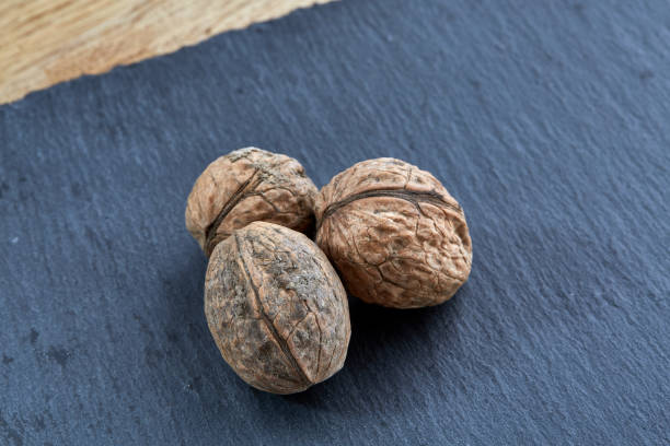 istock A stack of hard shells of walnuts piled together on dark piece of wood, selective focus 1010082692
