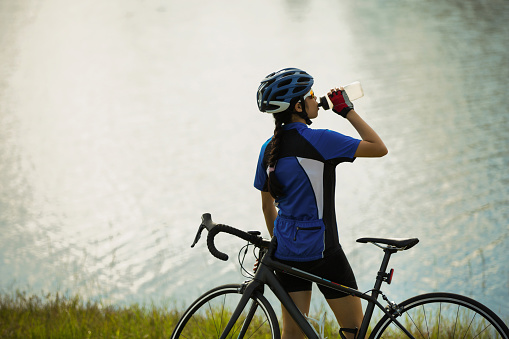 Asian women drinking water after cycling