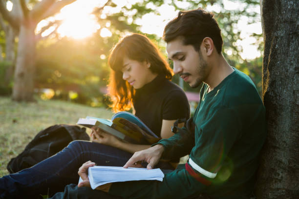 lo studente stava leggendo all'aria aperta e bel tempo. e sono felici.lens flare - student outdoors clothing southern africa foto e immagini stock