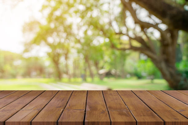 istock Empty wooden table top and green bokeh display montage for product with space. 1010093856
