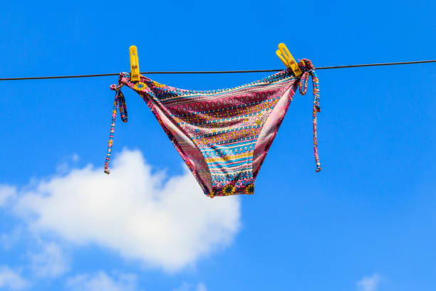 istock Drying female swimsuit hanging on a rope against blue sky 1010093894