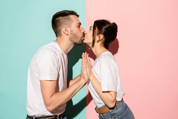 青色とピンク色の背景に愛情のあるカップル キス観 - couple indoors studio shot horizontal ストックフォトと画像