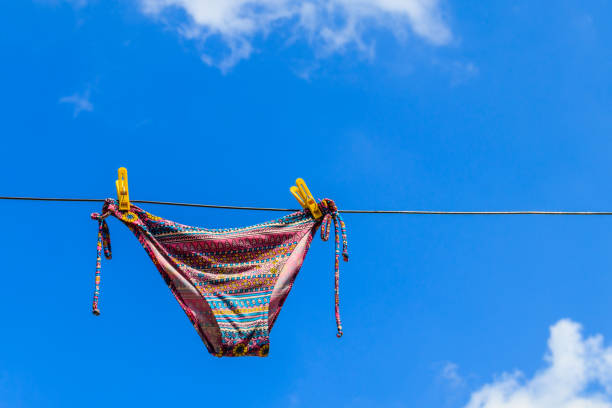 istock Drying female swimsuit hanging on a rope against blue sky 1010093912