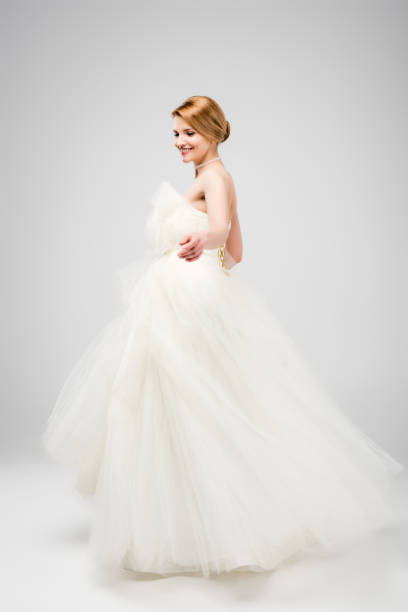 istock beautiful bride in white wedding dress, isolated on grey 1010099606